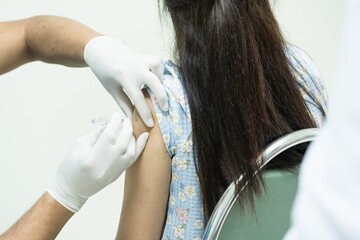 Close up doctor holding syringe make injection to patient in medical mask.Covid-19 or coronavirus...