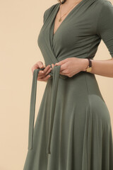 Serie of studio photos of young female model in green viscose wrap dress.