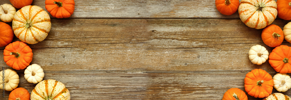 Poster fall double border of orange and white pumpkins over a rustic wood banner background. top view with 