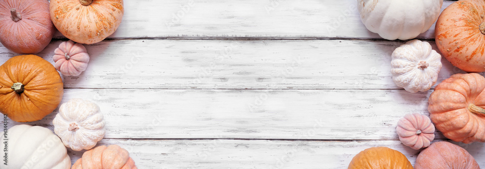 Poster autumn double border of pastel pumpkins of various sizes and colors over a rustic white wood banner 