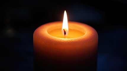 Close-up of a candle flame flickering softly, with a gentle glow illuminating the surrounding area and creating a serene atmosphere