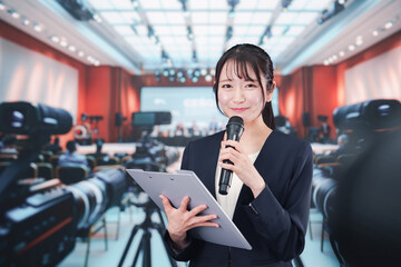 記者会見場からレポートをする女性記者