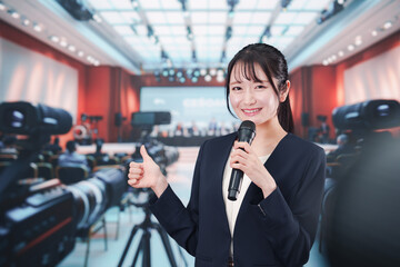 記者会見場からレポートをする女性記者