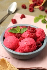 Delicious raspberry sorbet, fresh berries and mint in bowl on light table