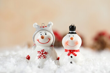 Funny snowman figures on artificial snow against blurred background