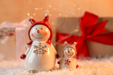 Funny snowman figures on artificial snow against blurred background