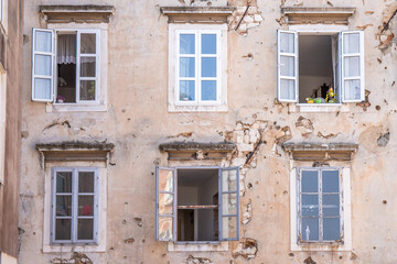 Window of an old building showing bullet holes from the Balkan War. Window front or house front in...