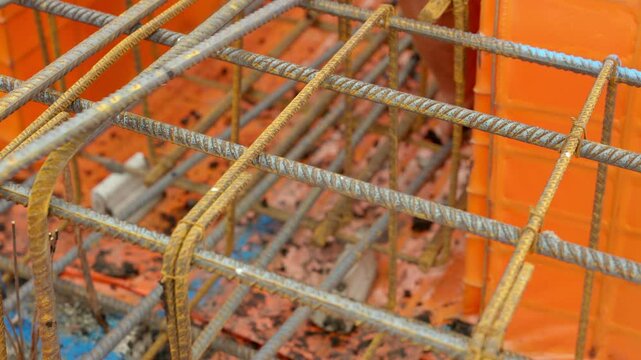 Rusty Rebar set inside plastic formwork  ready for concrete ground beam to be poured in a Vibrant Construction Site Reveals Layers of Progress and Artistry