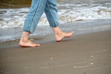 bare feet with blue pants on the beach