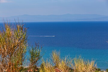sea and mountains and boat in pefkochori, greece
