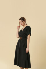 Fototapeta premium Serie of studio photos of young female model in soft cotton black midi dress. 