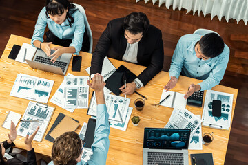 Two businessman shake hand in meeting room with coworker give cheerful applause. Team of analyst celebrate after successful significant progress on business strategic performance. Meticulous