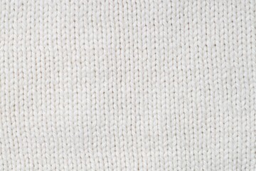 Texture of white knitted fabric as background, top view