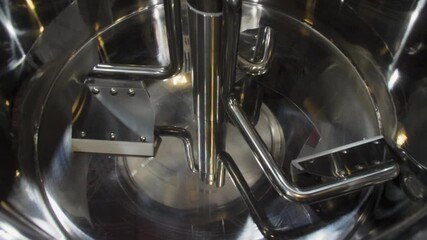 A close-up view captures the intricate design of a stainless steel mixing chamber, showcasing its components and how they facilitate efficient mixing in food processing.