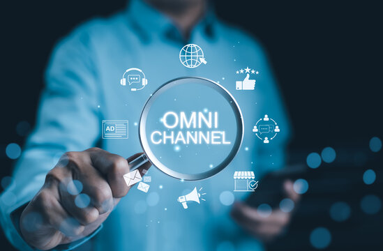 Omni Channel Marketing Concept. Multichannel Marketing, Businessman using magnifying glass with virtual icons omnichannel marketing strategies, customer engagement, digital communication, e-commerce,