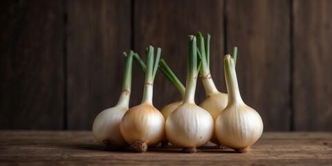 Four sweet white onions arranged on rustic wood.
