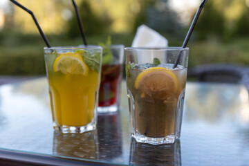 Two glasses of drinks with straws in them sit on a table