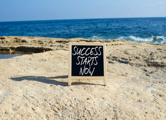 Success Starts Now symbol. Concept words Success Starts Now on black chalk blackboard. Beautiful...