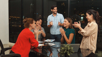 Businesspeople putting hands together and clapping hands to celebrate successful project at modern office with night city view. Group of manager with stacks of hands. Teamwork, trust. Tracery