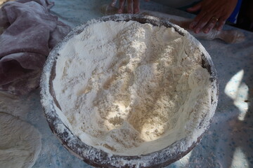 Fototapeta premium Female hands using flour in baking dough to make bread 