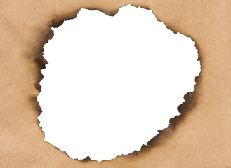 Fire burnt hole in brown paper on isolated background
