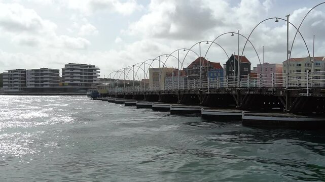 Queen Emma bridge is swinging, pontoon bridge across St. Anna Bay connecting Punda to Otrobanda berth of Willemstad, capital of Curacao in the Caribbean.