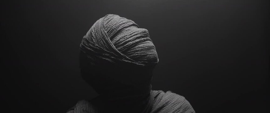 The mummy of a woman holds her face in her hands in a powerful pose