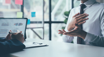Business Meeting: A serious conversation between two business professionals at a desk, focused on a...