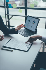 Business Meeting: A professional business meeting with a focus on data analysis. A man and a woman...
