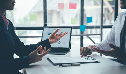 Business Presentation: A professional business meeting in a modern office, with two colleagues...