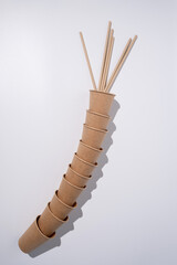 Top view of brown kraft paper cups, straws on a white table. Recyclable street food packaging. Zero waste. Paper dishes. Disposable takeaway cup