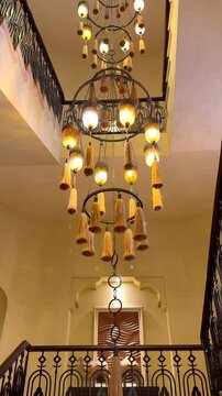 Steps lead to breathtaking modern chandelier designed with heritage influences. This long elegant fixture reaches from ceiling to floor casting glow that perfectly complements traditional Mable steps