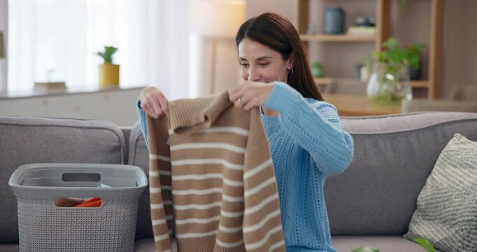 Laundry, happy and woman smell clothes with smile for housekeeping, spring cleaning and washing. Housewife, living room and aroma with basket of clothing, fresh linen or fabric scent for home comfort