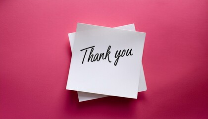 White sticky note with thank you note on pink background