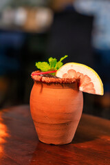 Cantarito Cocktail in Clay Mug with Grapefruit and Mint Garnish