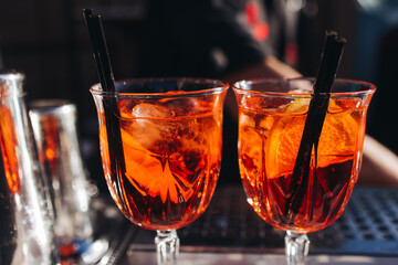 Bartender working, beautiful row line of different coloured liquor alcohol cocktails on a open air party in a bar, and others on catering banquet on event, barman mixing drinks and beverages in club