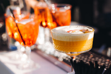 Bartender working, beautiful row line of different coloured liquor alcohol cocktails on a open air...