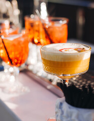 Bartender working, beautiful row line of different coloured liquor alcohol cocktails on a open air...
