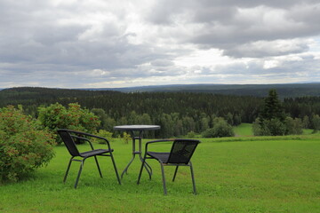 Summer day in August with clouds. Furniture outside. Distance landscape nature photo. Jämtland, Sweden, Europe.