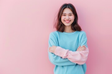 Obraz premium A woman stands confidently with her arms crossed, surrounded by a bright pink background
