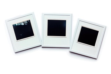 Three white picture frames with black photographs inside