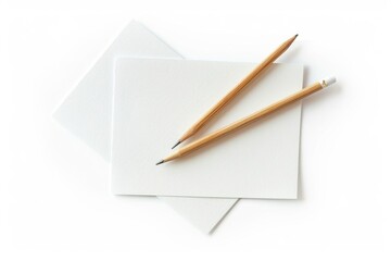 A pair of pencils resting on a piece of paper, ready for use