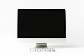 A computer monitor sits atop a white desk