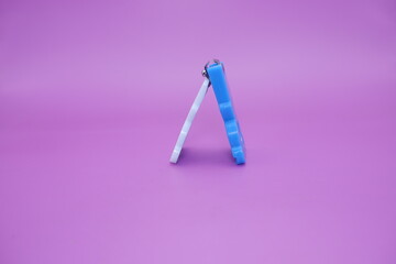 cute nail clippers isolated on purple background. cute nail clippers with blue and white color combination