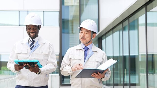 建物を歩く多国籍エンジニアのグループ