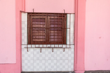 Cuba, Havana.old Havana pink wall, peeling  paint.  wrought iron, over winidow. 2016-04-06