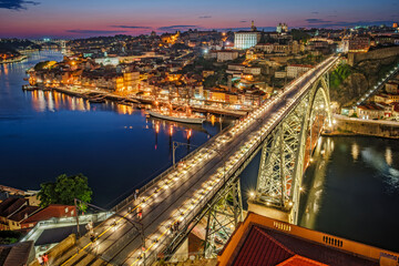 View of illuminated Porto city and Douro river and Dom Luis bridge I from famous tourist viewpoint...