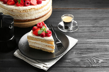 Tasty sponge cake with fresh berries and mint served on black wooden table, space for text
