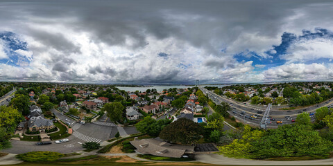 A stunning panoramic view of urban homes set against a sprawling highway and the Whitestone Bridge...