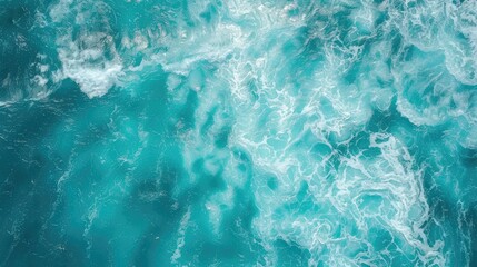 Obraz premium View of waves and ripples on the surface of a turquoise sea from an aerial perspective.
